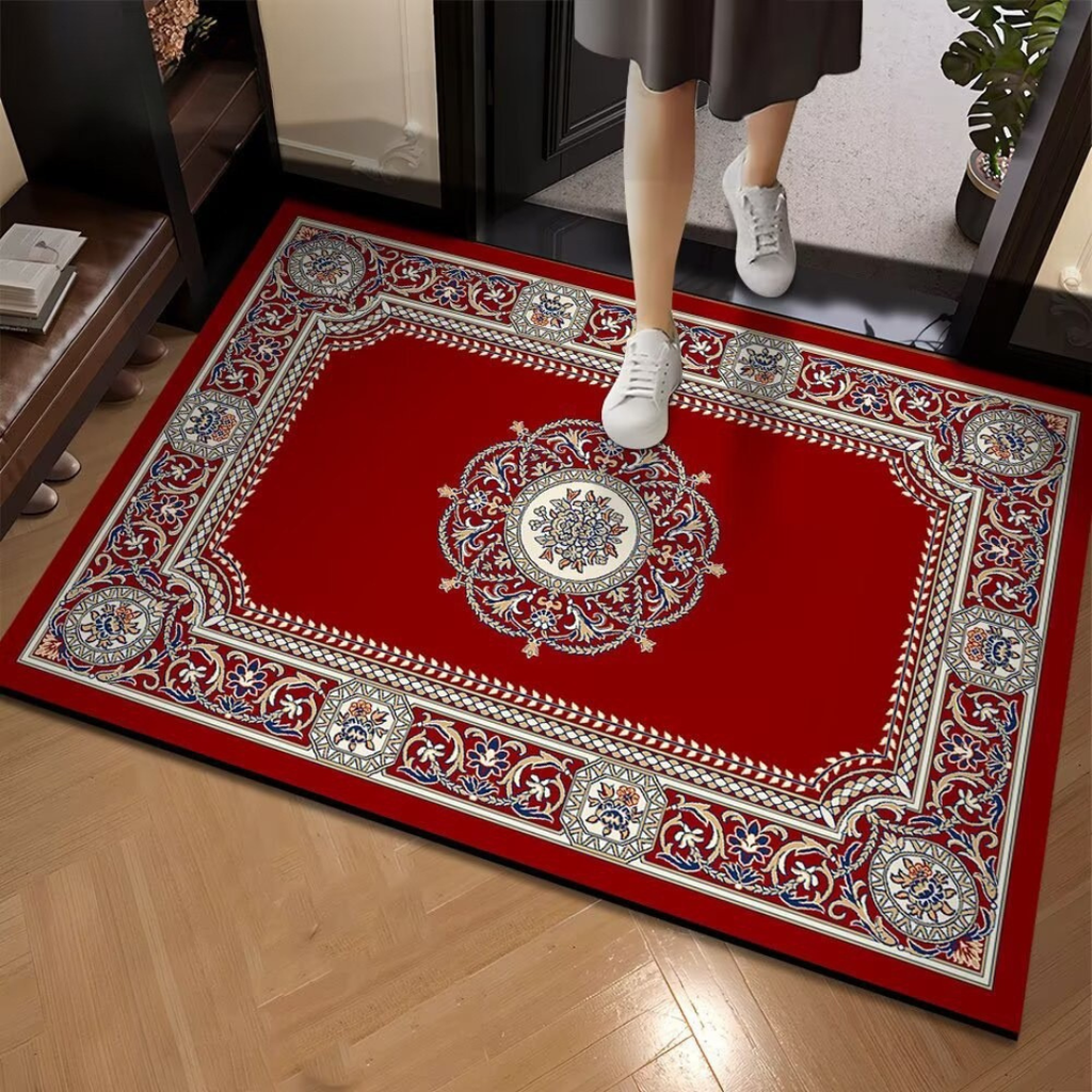 Decorative red rug with intricate patterns on a wooden floor, person stepping onto it.
