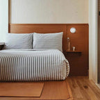 LYSEN - Nordic LED Wall Sconce - Minimalist Metal Wall Light, circular white light mounted beside the bed in a bedroom.