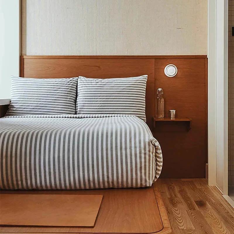 LYSEN - Nordic LED Wall Sconce - Minimalist Metal Wall Light, circular white light mounted beside the bed in a bedroom.