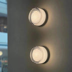 Nordic LED Wall Sconce, two circular ribbed metal wall lights mounted on a dark wall with a warm glow.