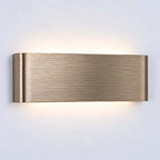 A modern rectangular wall sconce with a brushed brass finish, emitting a warm glow upwards and downwards against a plain light gray wall.