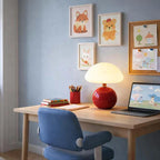 Nordic Ceramic Mushroom Table Lamp by Nordic Essentials on a desk in a child’s bedroom; red ceramic base, white shade.