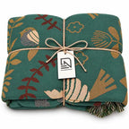 100% Cotton Reversible Throw Blanket with teal bird-pattern print, folded for sofa or bed, Nordic Essentials.