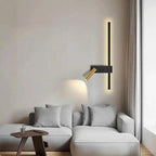 Swivel LED Wall Light with vertical black strip and brass adjustable head on living room wall beside sofa