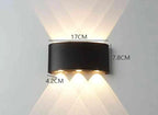 Modern Outdoor LED Wall Lamp, black metal mounted on wall, emits upward and downward glow for garden or living room.