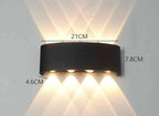 Modern Outdoor LED Wall Lamp, black metal fixture, wall-mounted, emitting upward and downward light on a white wall.
