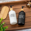 Two soap dispensers labeled 'HANDS' and 'DISHES' on a wooden surface with a wooden tray and plant in the background.