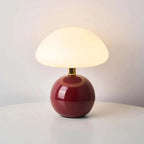 modern ceramic table lamp with a red base and white shade on a light gray background