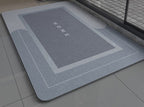 Blue gray non slip bath mat with 'HOME' text on a bathroom floor
