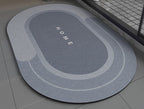 Blue gray non slip bath mat with 'HOME' text on a bathroom floor